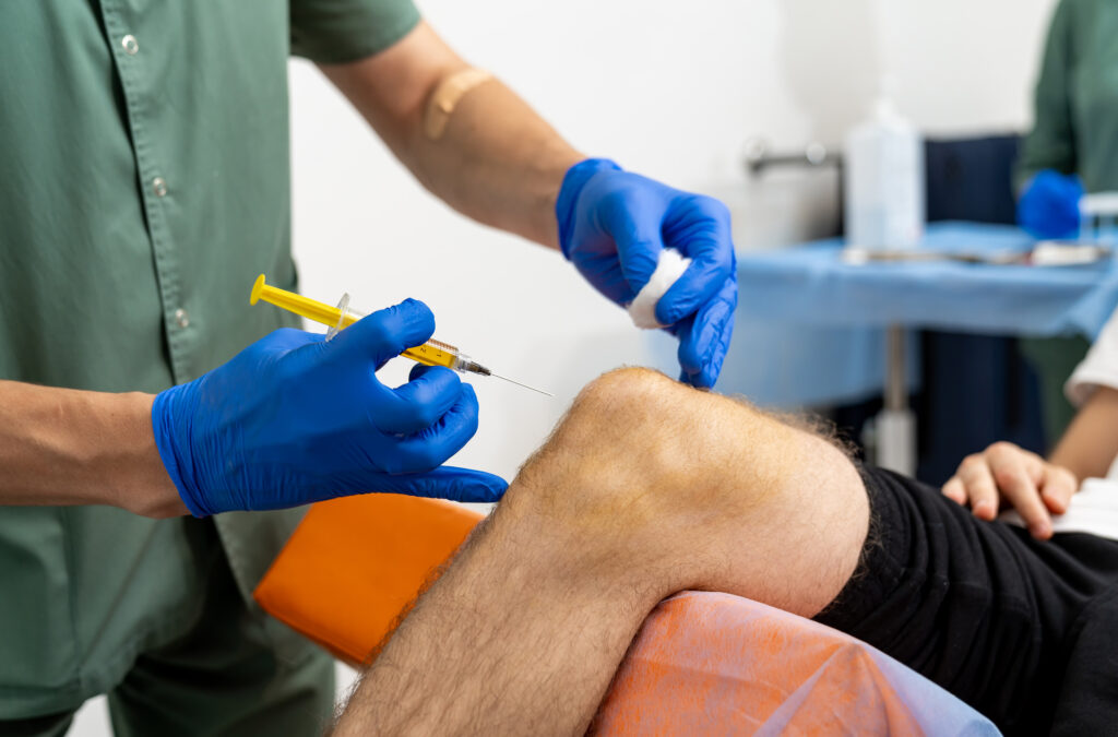knee medical injection doctor hand holding syringe injection knee